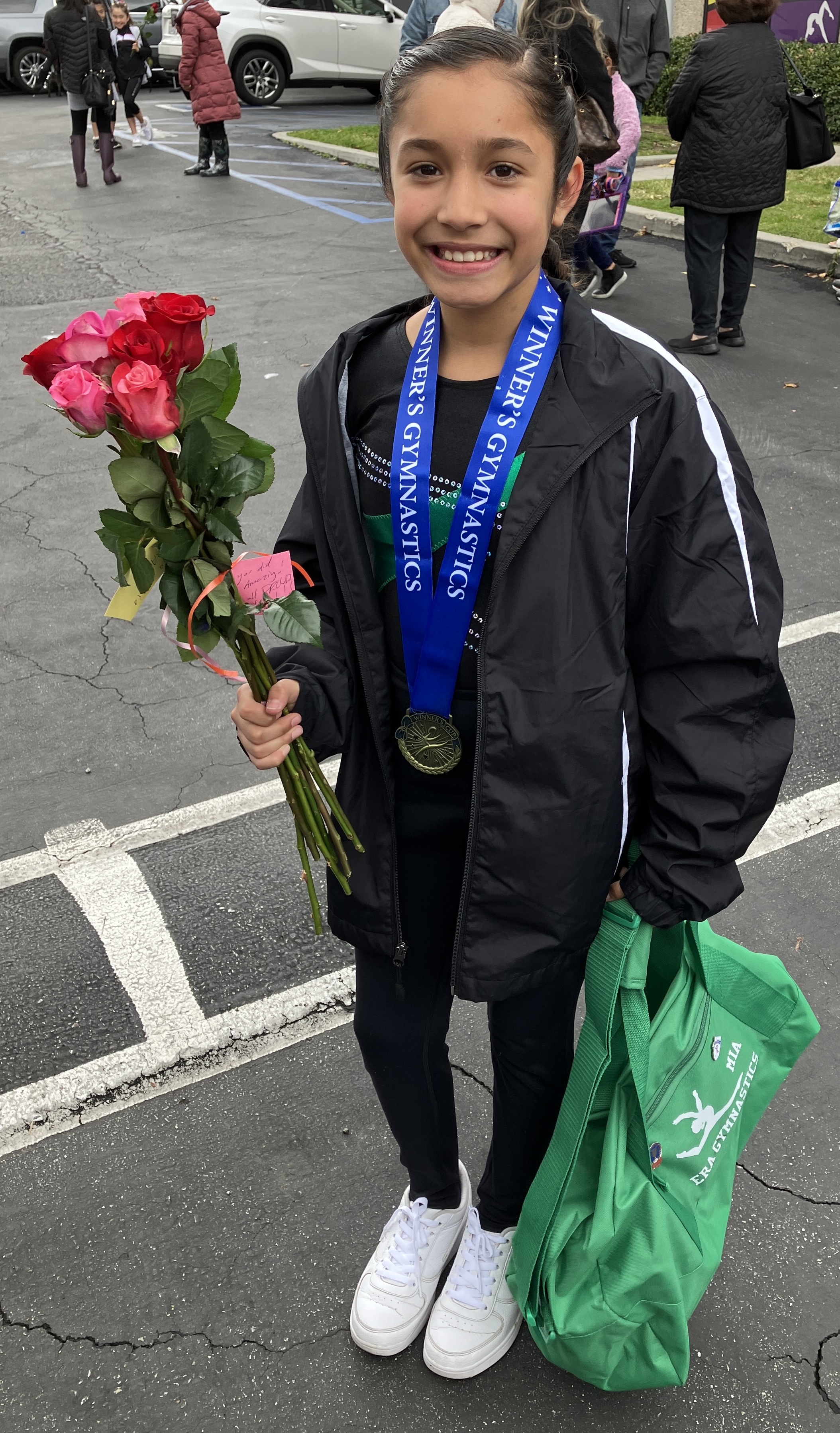 Photo of Mia with flowers after gymnastics meet